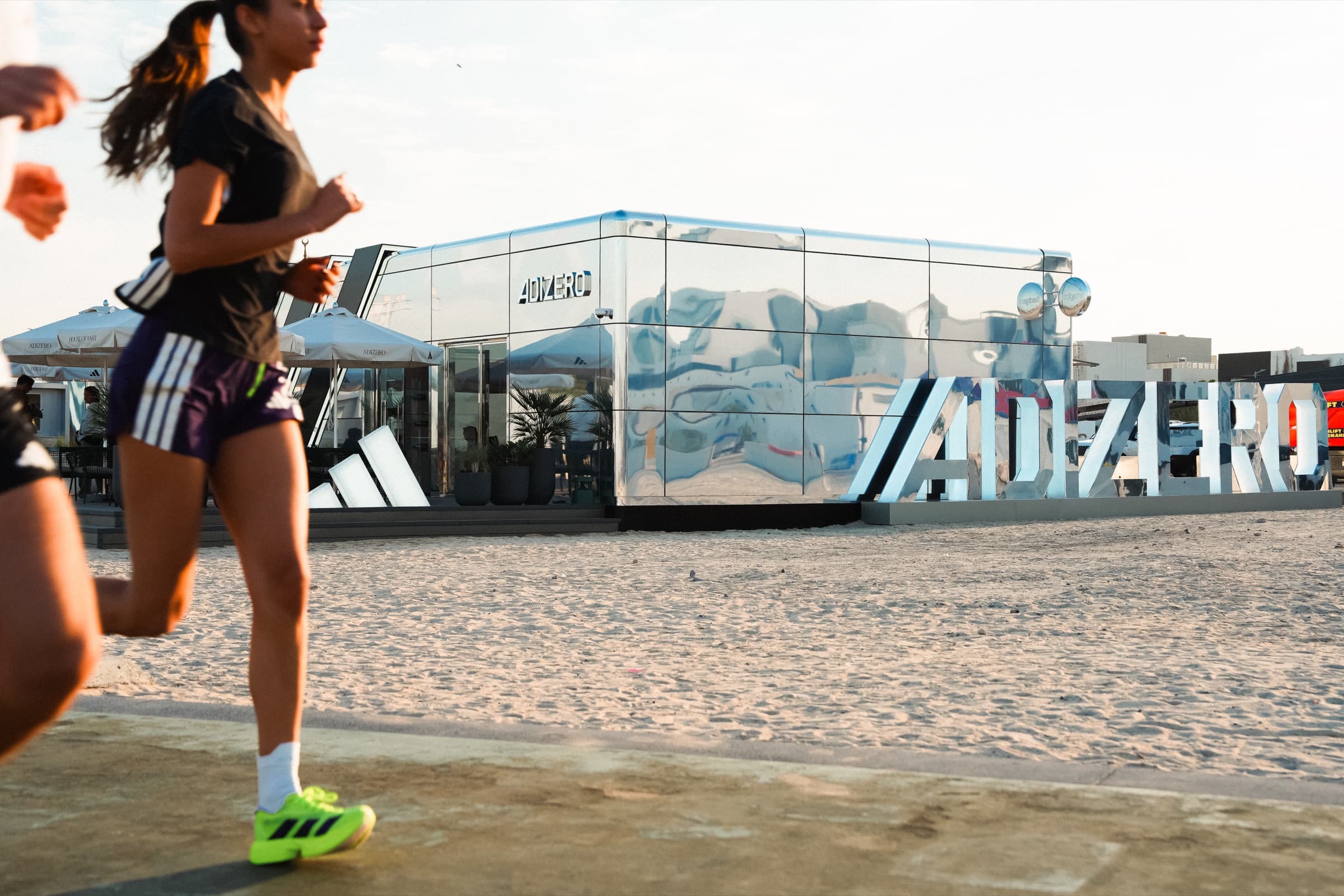 Runners passing House of Hybrid on the beach in Dubai