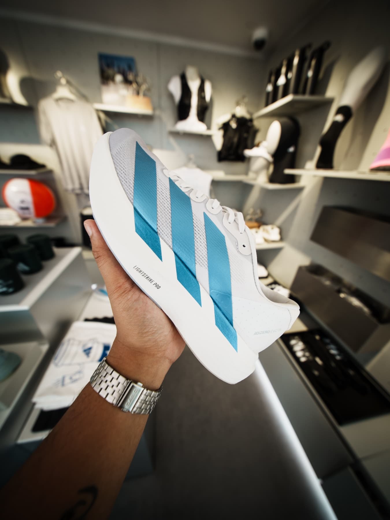 An adidas running shoe held up in the retail space