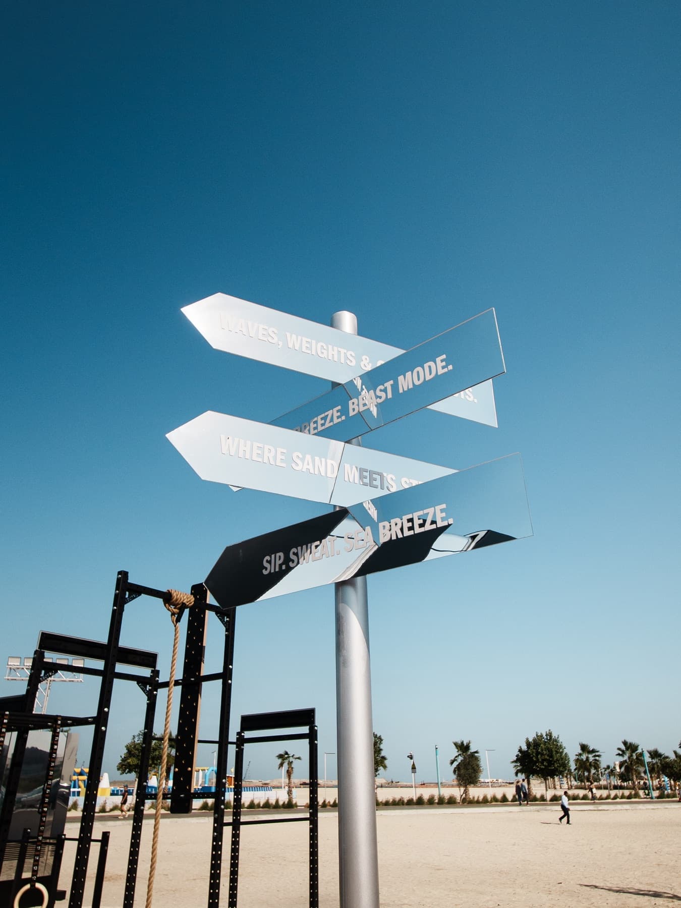 Mirrored House of Hybrid signposts against a blue sky